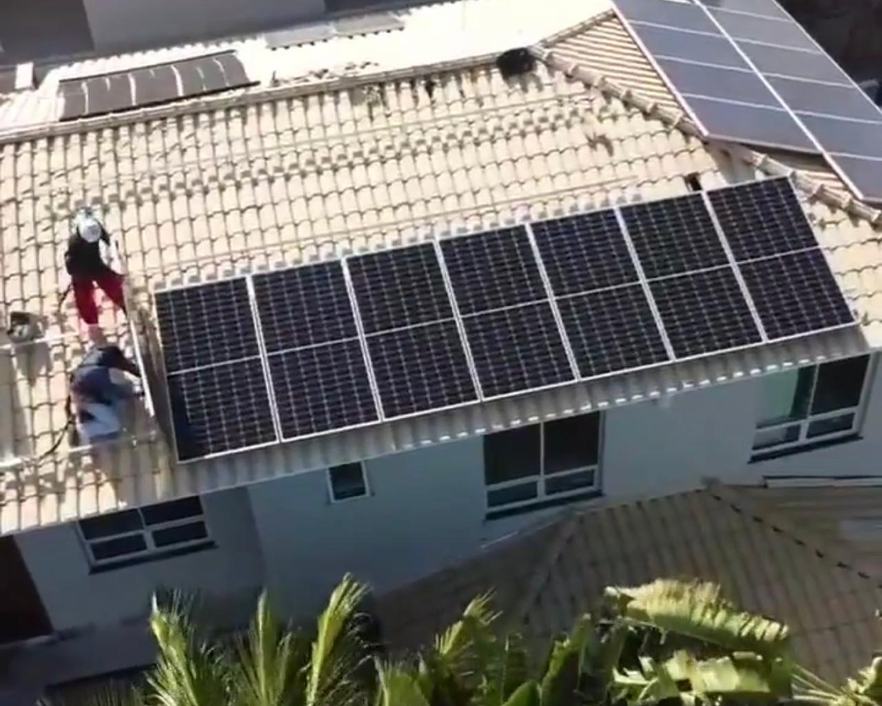 Equipe instalando painéis solares no telhado